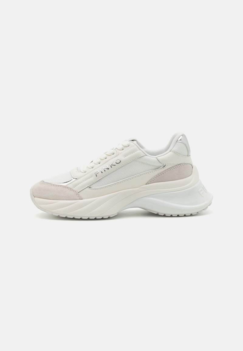 Sneaker bianca realizzata in materiali lisci e testurizzati, con una suola spessa, punta arrotondata e un branding discreto sul lato.