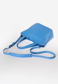 Borsa a tracolla in pelle blu con una forma strutturata, doppi manici superiori e una tracolla lunga regolabile. Texture liscia e dettagli di branding discreti.