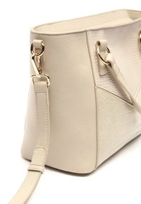 Borsa beige in pelle texture, con dettagli in materiale sintetico liscio, accessori in oro e tracolla regolabile. Presenta una forma rettangolare e sezioni a contrasto.