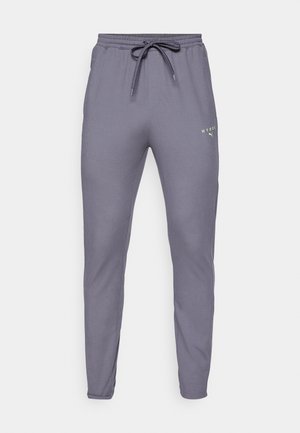 Gray athletic pants with a tapered fit, made of soft fabric. Features a drawstring waistband and a small neon green logo on the front.