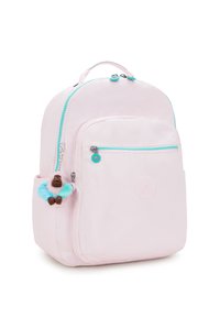 Světle růžový batoh s tyrkysovými zipy, přední kapsou a přívěskem. Hladký povrch s kulatým logem vyraženým na přední straně.