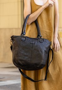 Must mustrist käekott, millel on kaks käepidet, reguleeritav õlarihm ja kuldne riistvara. Pehme tekstuur ja lõdva kuju.