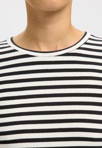 Fekete-fehér csíkos, bordázott póló kerek nyakkivágással, texturált anyaggal és egyenlő szélességű vízszintes csíkokkal.