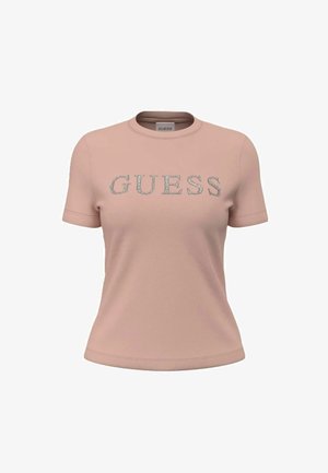 Camiseta de manga corta de color rosa claro con logo "GUESS" en pedrería plateada centrado en el frente, cuello redondo y corte ceñido.