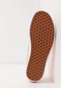 Semelle en caoutchouc avec un motif en grille texturé marron ; semelle intermédiaire blanche ; dessus en matière suédée orange vif.