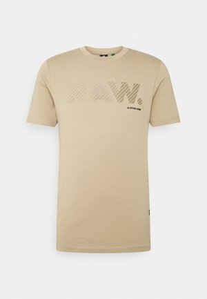Beige kurzärmliges Rundhals-T-Shirt mit "RAW."-Text in großen gestreiften Buchstaben und kleinem "G-STAR RAW"-Logo in der Mitte vorne.