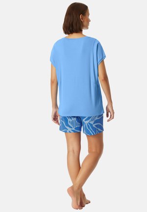 Hellblaues Kurzarmoberteil mit lockerer Passform, kombiniert mit blauen Shorts, die ein weißes Blättermuster aufweisen. Weicher Stoff und entspanntes Design.