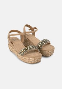 Sandalias de cuña de ante beige con una suela de yute trenzado grueso, adornadas con una tira de joyas y un hebillaje en el tobillo para un ajuste seguro.