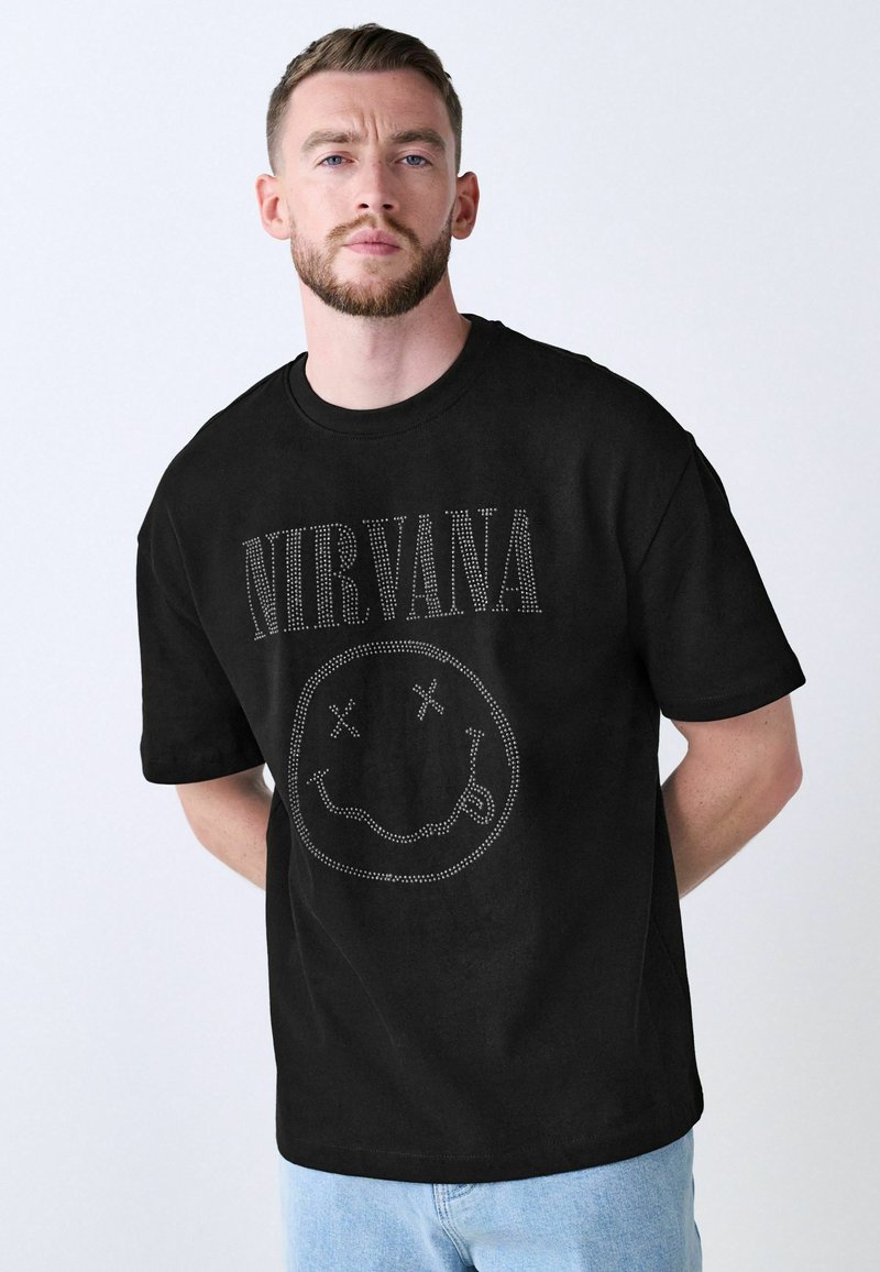 Black cotton t-shirt featuring a rhinestone Nirvana graphic on the front, short sleeves, and a crew neckline. Classic slim fit design.