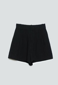 Shorts noirs à taille haute, coupe ajustée, avec passants pour ceinture, plis sur le devant et ouverture large au niveau des jambes, posés à plat sur un fond gris.