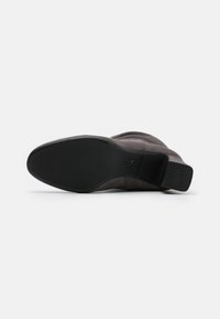 Stivale alla caviglia in suede grigio con punta affusolata, tacco a colonna e suola in gomma nera testurizzata. Presenta cuciture sottili e un design minimalista.