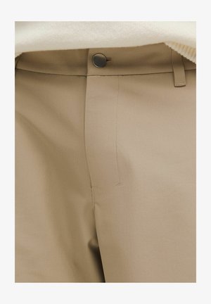 Beige trousers featuring a smooth fabric texture, a flat waistband, side pockets, and a small metal button closure at the front.