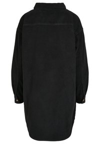 Veste-chemise en velours côtelé noir avec col, manches longues, empiècement au dos et poignets boutonnés. Tissu texturé avec une coupe décontractée.