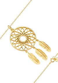 Zelts sapņu  ķērājs ar sarežģītu tīkla dizainu un trim karājošām spalvu akcentiem. Iekļauj gludu ķēdi ar aizdari.