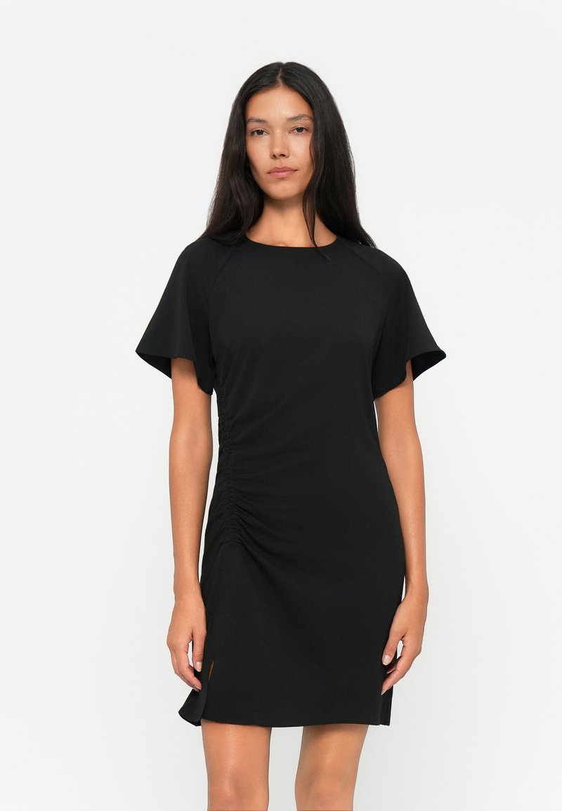 Schwarzes Kleid mit kurzen, fließenden Ärmeln, seitlichem Raffung und einem leichten Schlitz am Saum. Hergestellt aus einem glatten, dehnbaren Stoff.