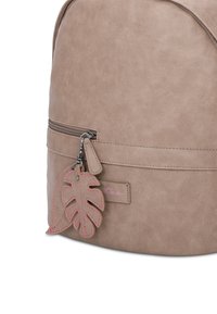 Mochila de piel sintética beige con un bolsillo con cremallera y un tirador de cremallera en forma de hoja con acentos rosados. Diseño simple y práctico.