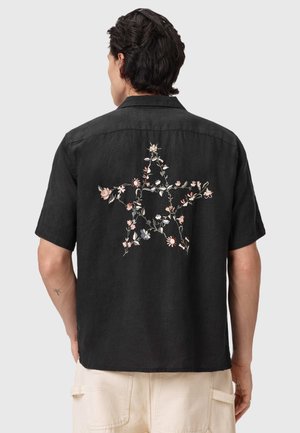 Sort kortærmet skjorte med blomsterbroderi i stjerneform på ryggen. Fremstillet af let stof med en tekstureret finish.