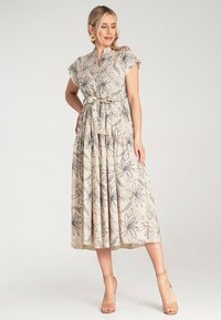 Beiges Midi-Kleid mit kurzen Ärmeln, gerafftem Taillenteil und schwarzen Blumenmustern. Es hat eine durchgehende Knopfleiste und einen ausgestellten Rock.