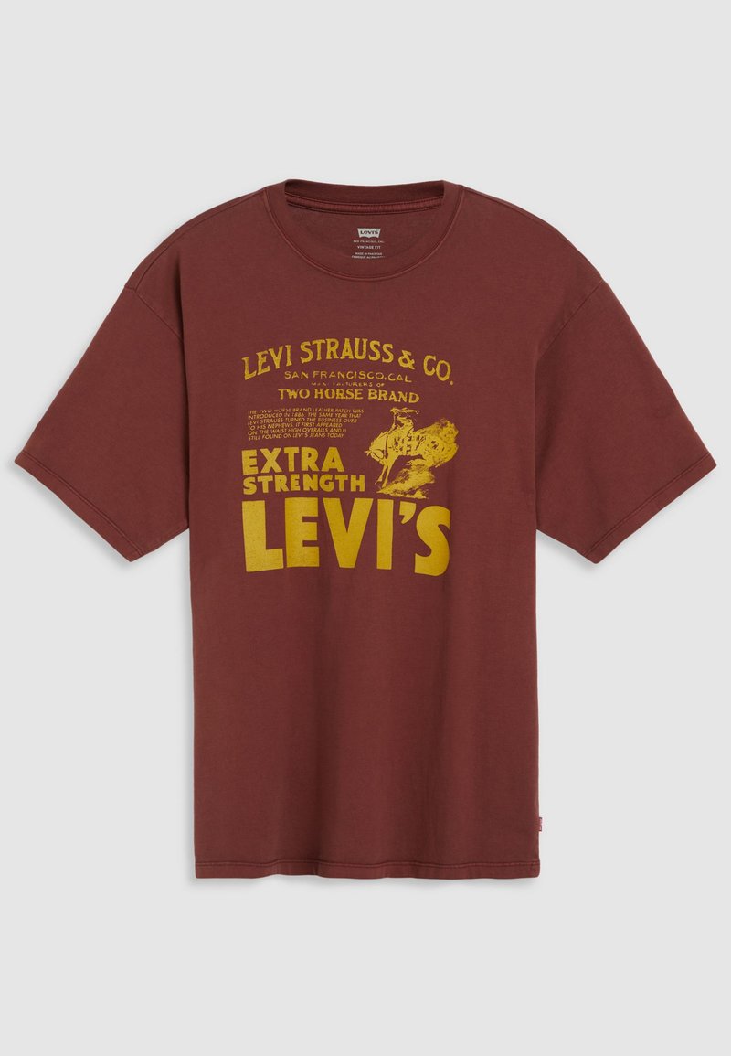 Camiseta de algodón burdeos con estampado gráfico amarillo de estilo vintage que incluye el nombre de la marca y detalles, mangas cortas y cuello redondo.