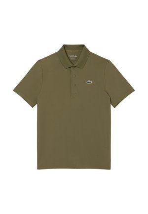 Polo vert olive en tissu lisse. Présente un col classique, trois boutons et un petit logo Lacoste vert sur la poitrine gauche.