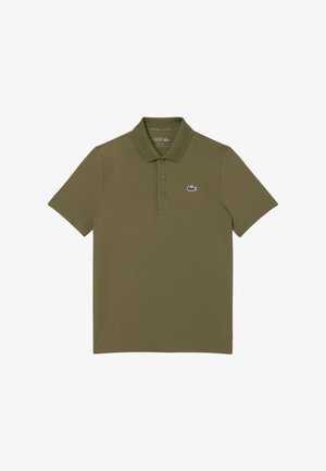 Polo vert olive en tissu lisse. Présente un col classique, trois boutons et un petit logo Lacoste vert sur la poitrine gauche.