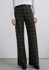 Pantalons à carreaux brun et gris avec une taille haute, des jambes larges et une texture lisse. Présente une fermeture frontale élégante et des poches arrière.