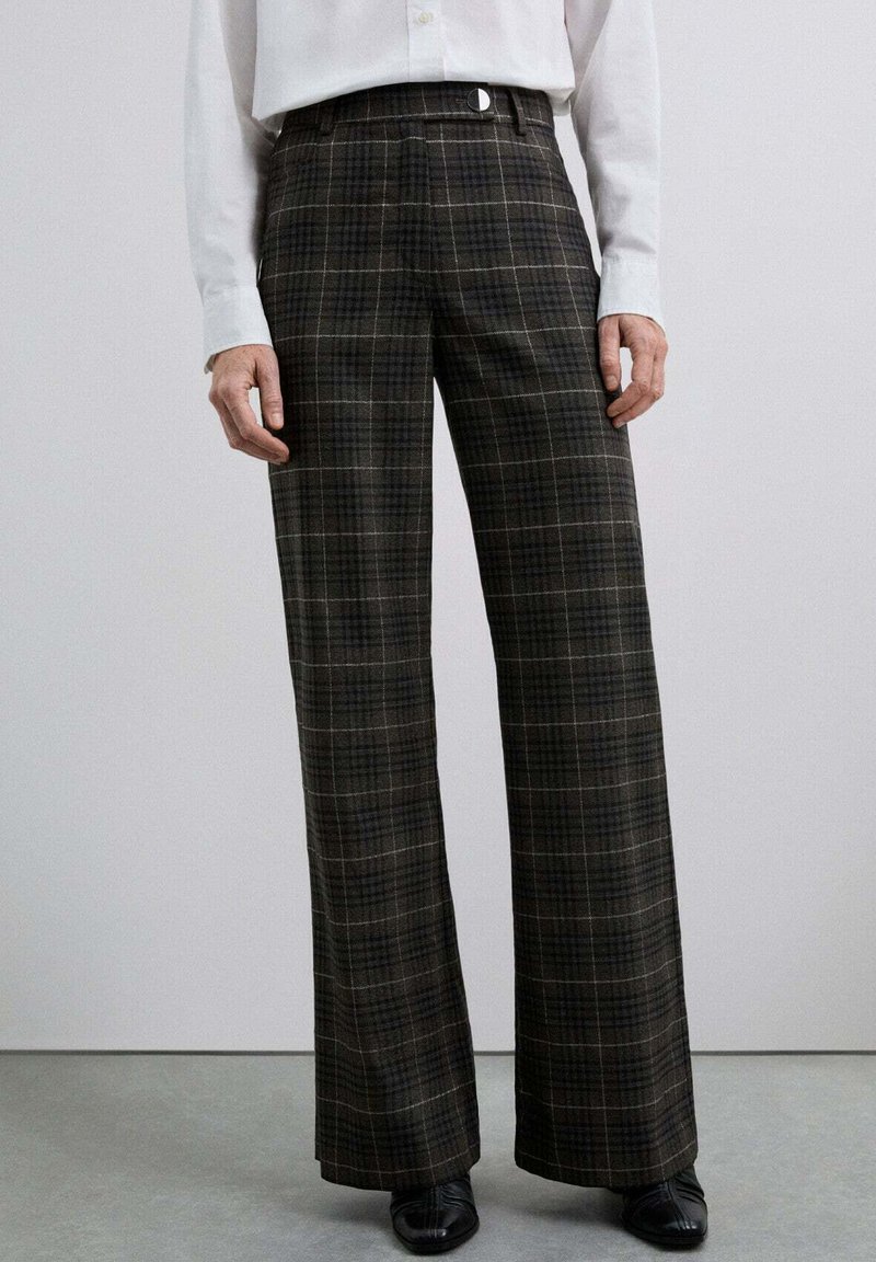 Pantalons à carreaux brun et gris avec une taille haute, des jambes larges et une texture lisse. Présente une fermeture frontale élégante et des poches arrière.