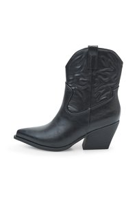 Stivali da cowboy in finta pelle nera con punta affusolata, dettagli testurizzati lungo il gambale e tacco spesso. Dotati di linguetta per un facile utilizzo.