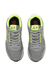 Le sneakers grigie presentano una tomaia in suede e rete testurizzata con dettagli verde neon, lacci piatti e una suola in gomma nera. L'interno è dotato di una soletta con logo.