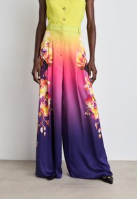 Farbige weite Hosen aus Seidenmischung mit einem Ombre-Design, das einen lebhaften Farbverlauf von Pink zu Lila zeigt, sowie florale Muster an den Seiten.