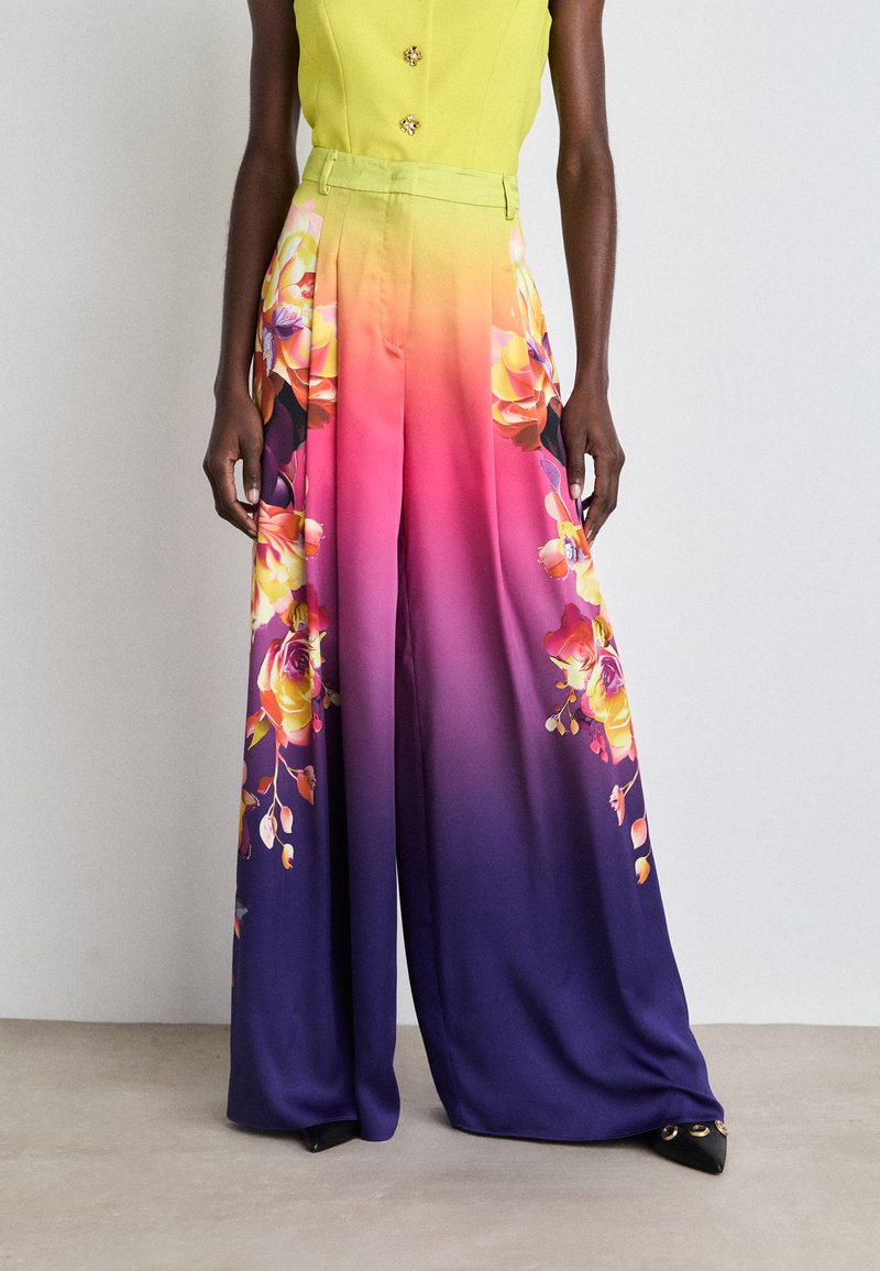 Farbige weite Hosen aus Seidenmischung mit einem Ombre-Design, das einen lebhaften Farbverlauf von Pink zu Lila zeigt, sowie florale Muster an den Seiten.