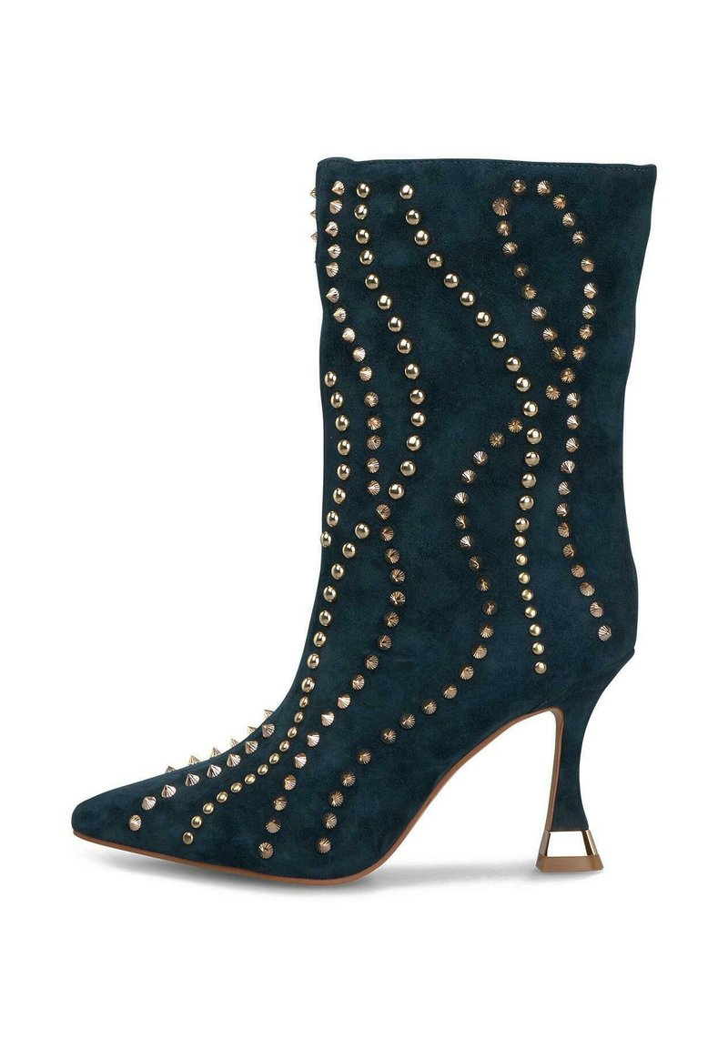 Botín de ante negro con punta afilada, tacón acampanado de altura media y tachuelas doradas decorativas en patrones ondulados.