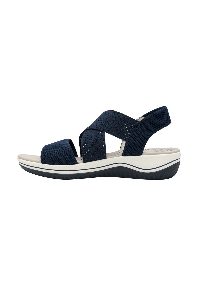 Navy blue sandal with perforated straps, open toe, cushioned footbed, and a white and navy sole featuring a wave pattern.