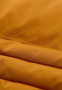 Strukturierter Stoff in verbranntem Orange mit sichtbaren Falten und Knicken. Das Material wirkt strapazierfähig mit einer glatten Oberfläche und einem subtilen Glanz.