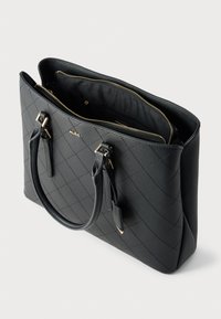 Sac cabas matelassé noir avec garnitures dorées, doté de deux poignées et d'un intérieur spacieux avec fermeture éclair et poche intérieure. Finition texturée.