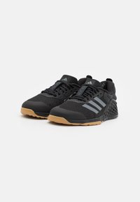 Scarpe sportive nere con tomaia in rete, design a tre strisce grigie e suola in gomma con tacco decorato.