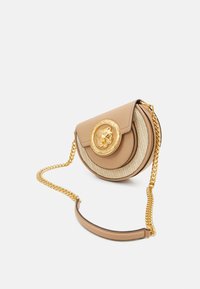 Borsa a tracolla in pelle e paglia beige con emblema dorato a forma di leone, forma rotonda, tracolla a catena e texture liscia.