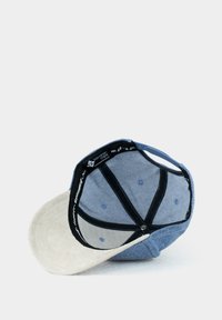 Blue and beige cap with a soft, suede brim, denim body, internal mesh lining, and black stitching details. Features adjustable strap.