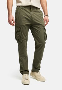 Pantalones cargo en verde oliva, hechos de una tela ligera, con bolsillos laterales, un ajuste relajado y cierre de botón en la cintura.