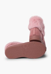 Botine din suede roz cu o mansetă pufoasă din blană sintetică roz, talpă din cauciuc texturat cu modele în zigzag și accente de cusături contrastante.