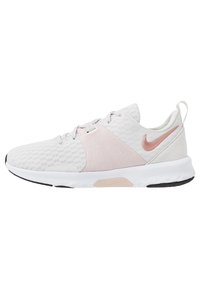 Scarpa sportiva Nike in mesh bianco e pelle con dettagli rosa. Presenta un design leggero, pannello laterale testurizzato e suola in gomma flessibile.