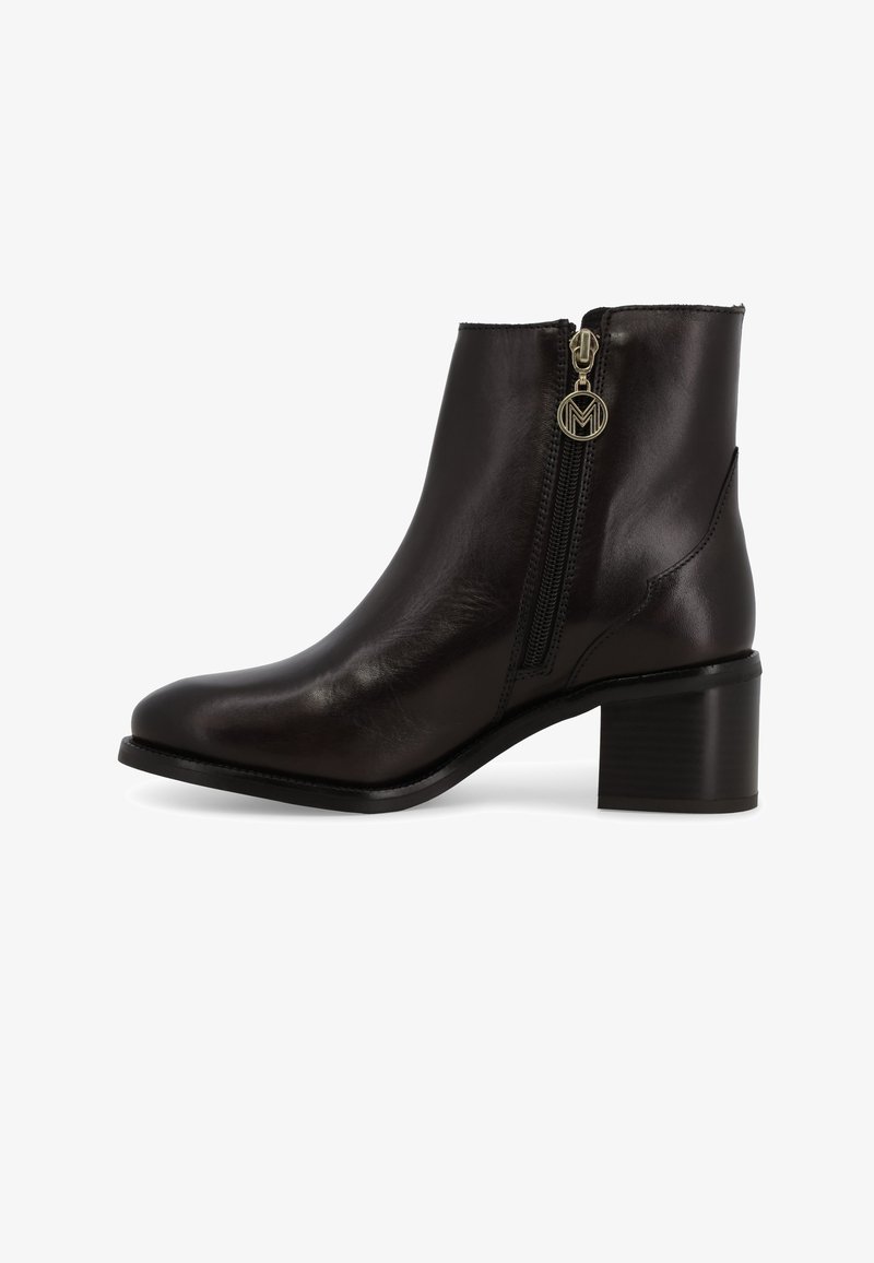 Stivaletto alla caviglia in pelle nera con punta arrotondata, cerniera laterale con tirante circolare e tacco a blocco di altezza moderata.