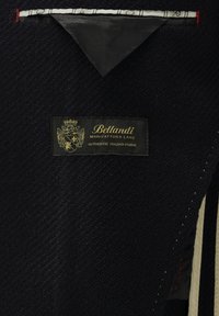 Dunkel marineblauer Stoff mit einer strukturierten Webart, versehen mit einem goldenen Etikett mit der Aufschrift "Bellandi", das authentischen italienischen Stoff anzeigt. Weiße Nähte akzentuieren das Design.