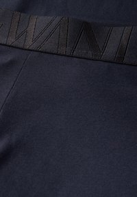 Černé atletické šortky s texturovaným pasem vyrobené z hladké látky. Šortky jsou tmavě modré s jemnými vzory na povrchu.