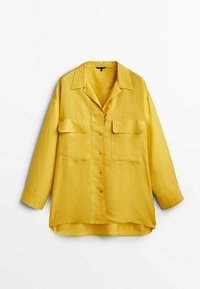 Chemise jaune à manches longues avec boutons, avec deux grandes poches frontales et un large col, présentée sur fond blanc.