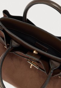 Sac à main en cuir marron avec extérieur lisse, deux poignées, compartiments intérieurs et détails en métal doré. Texture douce et design structuré.