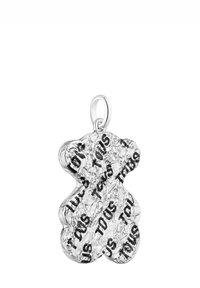 Ciondolo a forma di orsetto in argento con superficie testurizzata, con il nome del marchio "Tous" ripetuto in caratteri neri sul corpo.