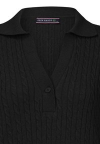 Pull en maille noire avec un col en V, présentant un motif en câble, des bords côtelés et un détail de bouton au col. Étiquette de marque visible.
