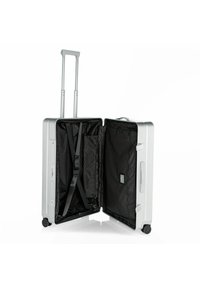 Silberner Hartschalenkoffer, geöffnet, um das schwarze Innere mit Netztaschen, verstellbaren Riemen und Rädern zu zeigen. Teleskopgriff sichtbar.