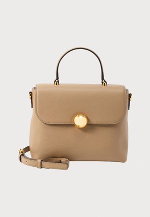 Bordo spalvos odinė rankinė su viršutine rankena, užsegimu su skląsčiu, auksinio spalvos apskritu užraktu ir reguliuojama petneša ant šviesaus fono.